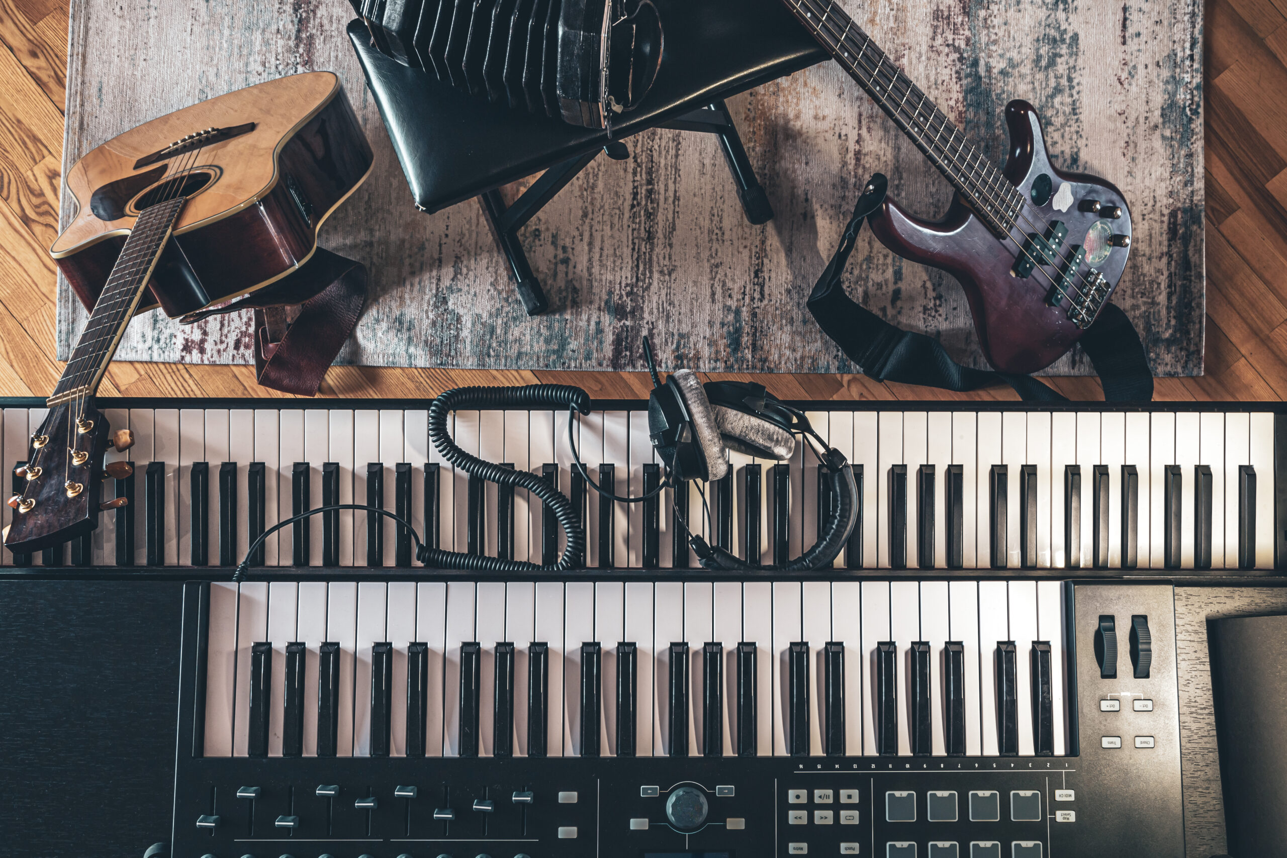 Piano keys, acoustic guitar and other instruments, top view, musician's workplace.